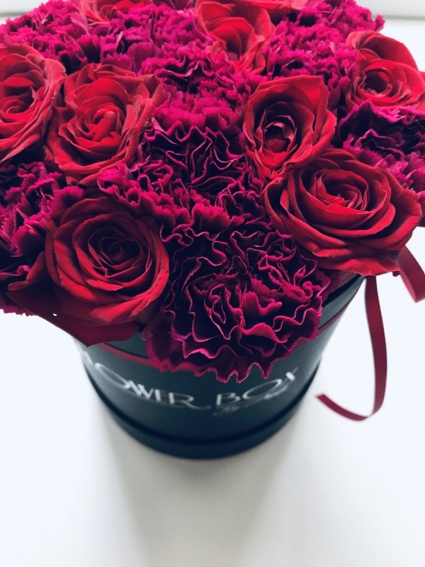 Mix czerwonych żywych róż z goździkami w średnim czarnym boxie