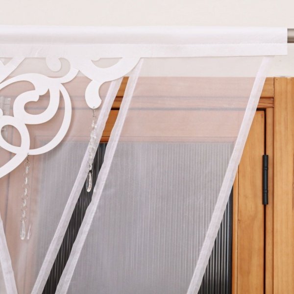 Zbliżenie na fakturę gładkiego białego woalu i precyzyjne łączenie z ażurowym elementem dekoracyjnym.