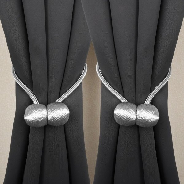 Sposób upięcia ciemnych zasłon za pomocą jasnoszarej spinki magnetycznej – elegancki kontrast i upięcie w kokon.
